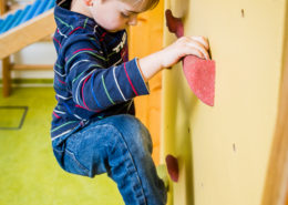 Kind an Kletterwand